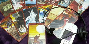 Imagen de algunas cartas de tarot junto a un teléfono, representando el tarot económico por teléfono.
